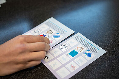 Eine Hand mit zwei Stempelkarten der Ausbildungsrallye