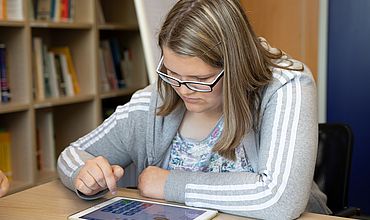 Eine Schülerin arbeitet mit dem Tablet.