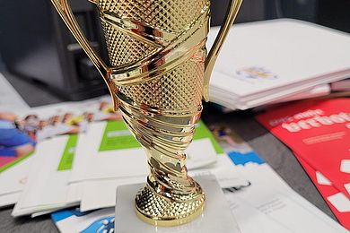 Goldener Pokal mit dem Schild "Sieger Inklusionscup 8.12.2022"